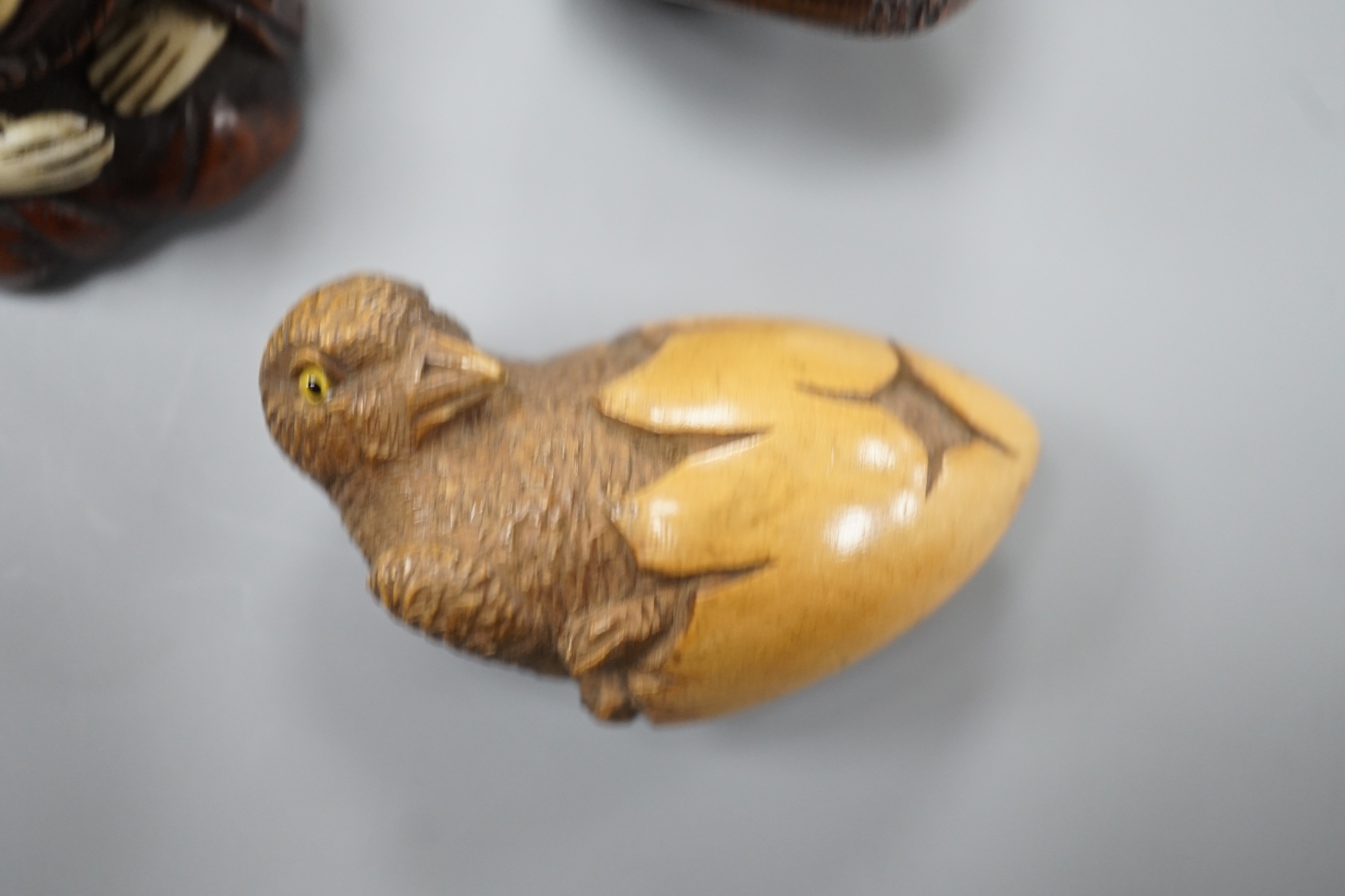 A Continental wood ‘chick and egg’ brooch ivory, 5.3cm, a Japanese ivory and wood figure and a wood netsuke of snakes (3)